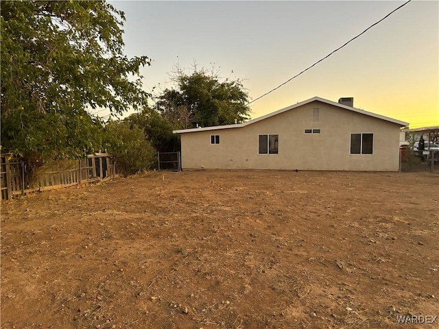 back of house with fence and stucco siding