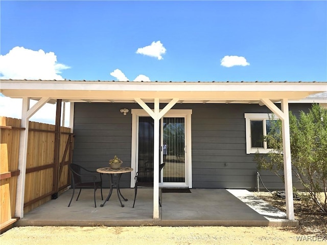 back of house featuring metal roof, a patio, and fence