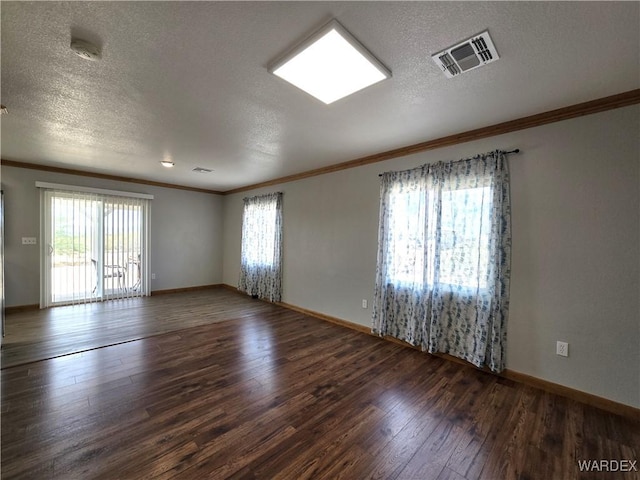 spare room with visible vents, dark wood finished floors, and a textured ceiling