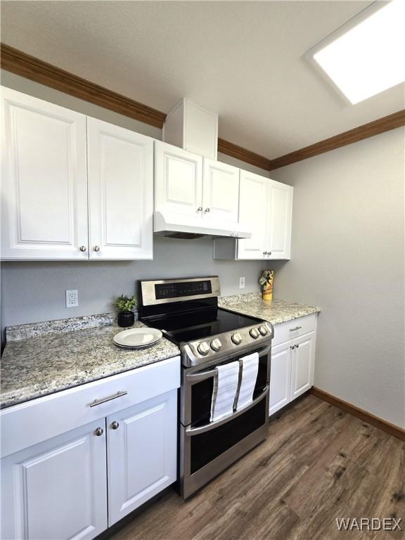 kitchen with under cabinet range hood, dark wood-style flooring, white cabinets, double oven range, and crown molding