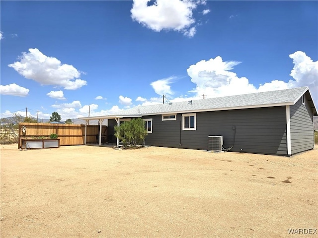 rear view of property featuring fence and central AC unit