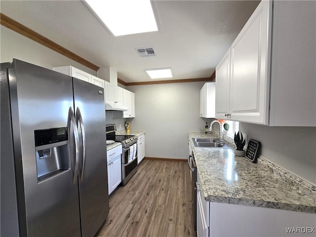 kitchen with stainless steel appliances, visible vents, and white cabinetry