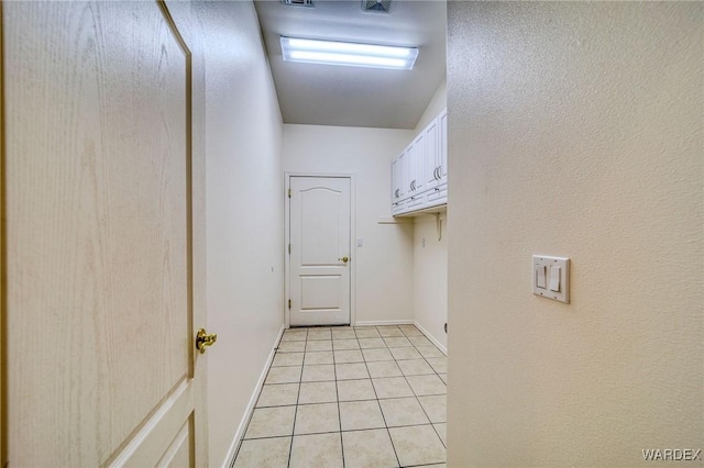 interior space featuring light tile patterned floors and baseboards