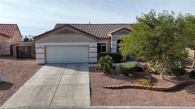 view of front of house featuring a garage, concrete driveway, a tile roof, and stucco siding