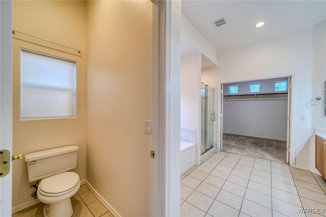 bathroom with a walk in closet, visible vents, toilet, a shower stall, and tile patterned floors