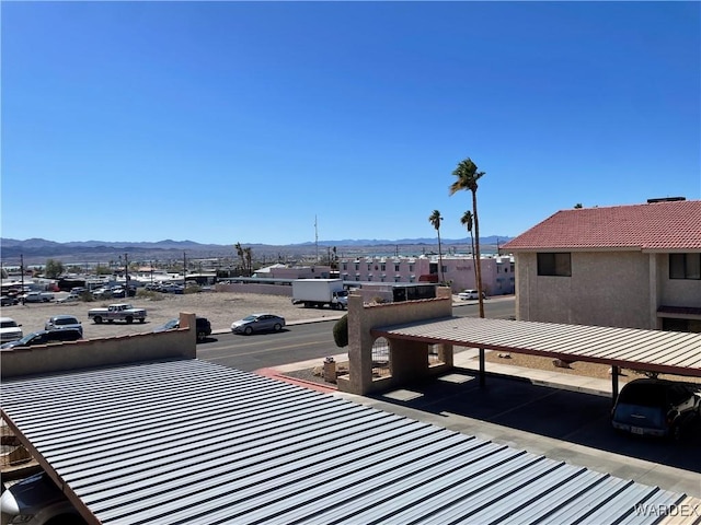 exterior space with a mountain view, a tiled roof, and stucco siding