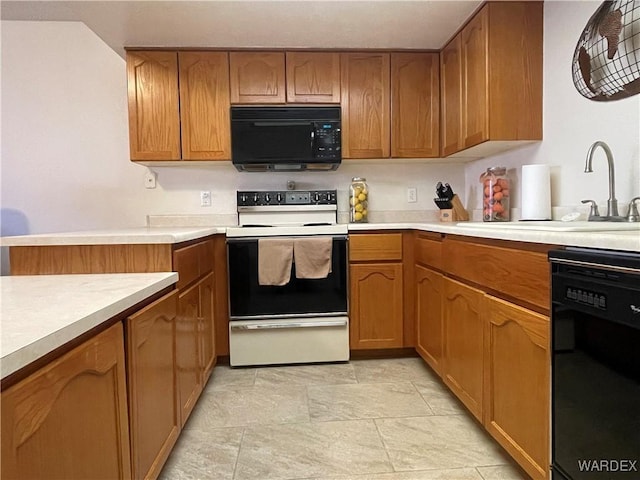 kitchen with brown cabinets, light countertops, a sink, and black appliances