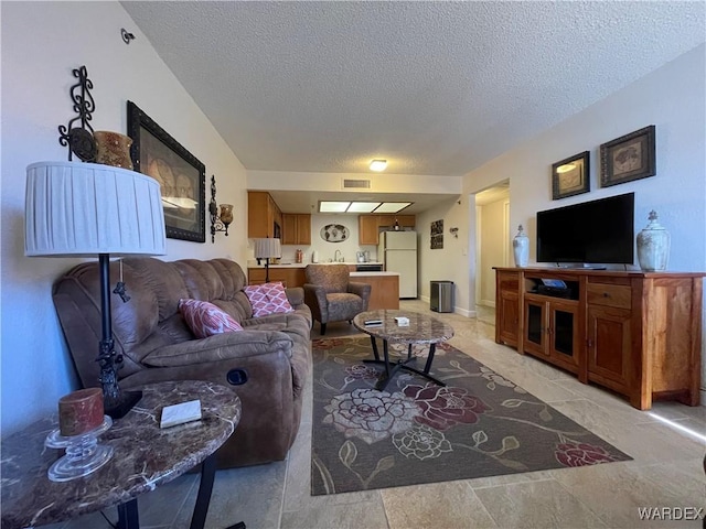 living area with visible vents and a textured ceiling