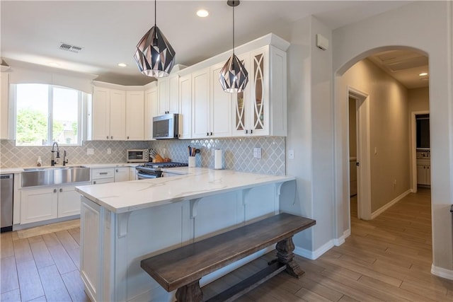 2178 E Via Lucio, Fort Mohave, AZ 86426 - kitchen featuring a sink, stainless steel appliances, arched walkways, light wood-style flooring, and recessed lighting