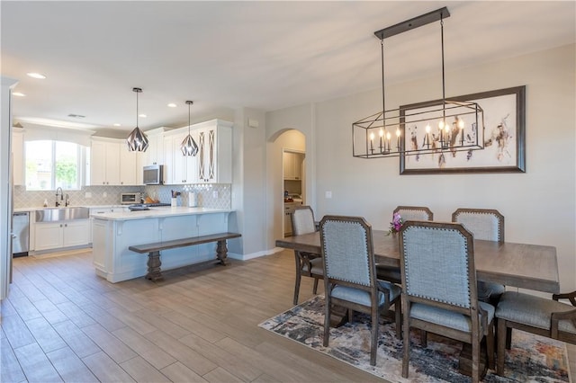 2178 E Via Lucio, Fort Mohave, AZ 86426 - dining space featuring arched walkways, light wood finished floors, a chandelier, and recessed lighting