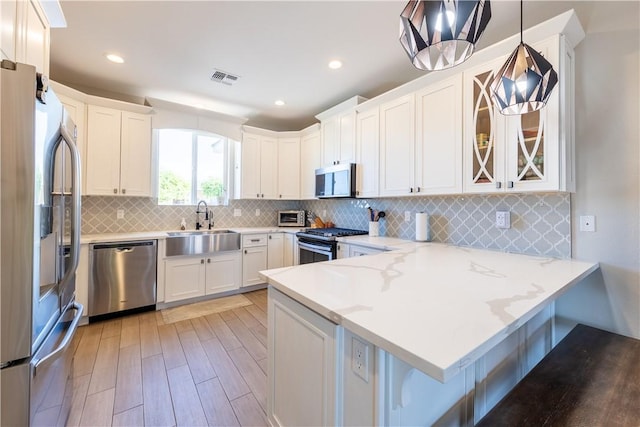 2178 E Via Lucio, Fort Mohave, AZ 86426 - kitchen with stainless steel appliances, a peninsula, light wood-type flooring, a sink, and a breakfast bar area