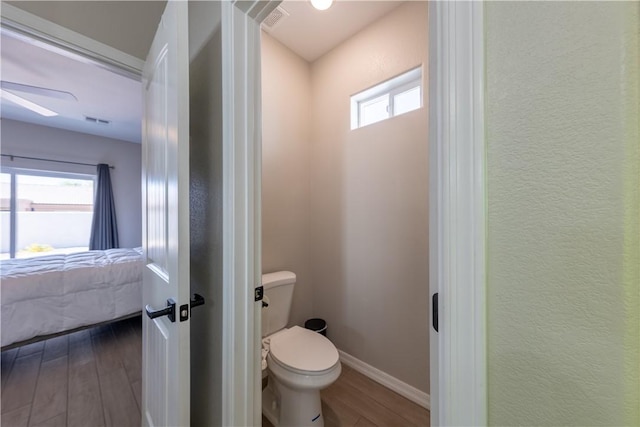2178 E Via Lucio, Fort Mohave, AZ 86426 - bathroom featuring wood finished floors, connected bathroom, toilet, baseboards, and a ceiling fan