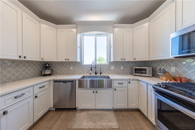 2178 E Via Lucio, Fort Mohave, AZ 86426 - kitchen with stainless steel appliances, a sink, light wood-style flooring, white cabinets, and light countertops
