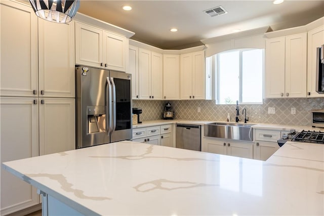 2178 E Via Lucio, Fort Mohave, AZ 86426 - kitchen with stainless steel appliances, a sink, recessed lighting, backsplash, and light stone countertops