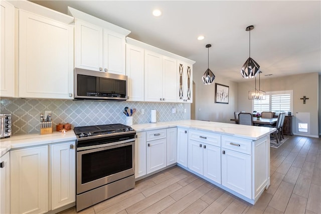 2178 E Via Lucio, Fort Mohave, AZ 86426 - kitchen featuring appliances with stainless steel finishes, a peninsula, light wood-style flooring, white cabinets, and recessed lighting