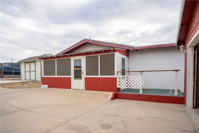 view of front of property featuring a patio area and fence