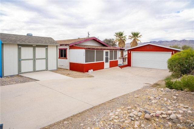 view of front of house featuring a detached garage, a mountain view, and an outdoor structure