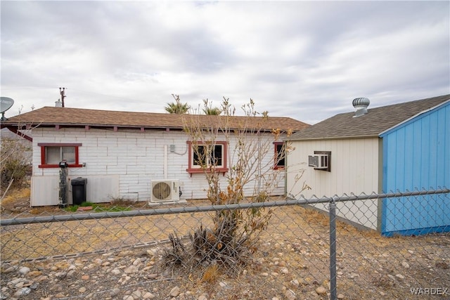 view of side of home featuring ac unit, fence, an AC wall unit, and roof with shingles