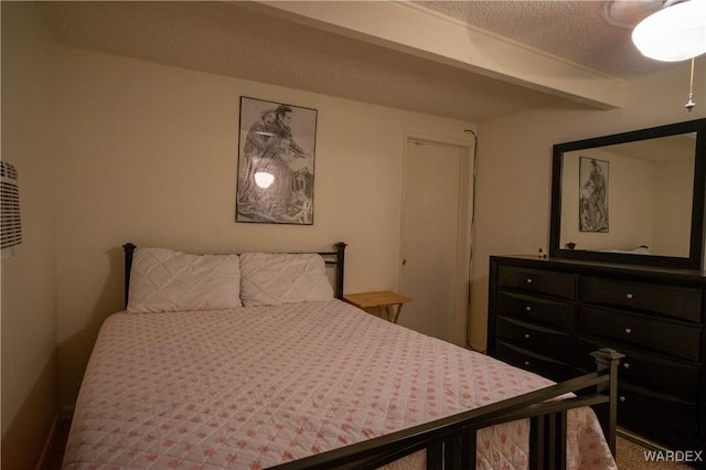 bedroom featuring a textured ceiling and beamed ceiling