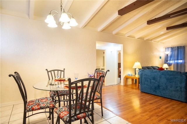 dining space featuring vaulted ceiling with beams, light wood finished floors, and an inviting chandelier