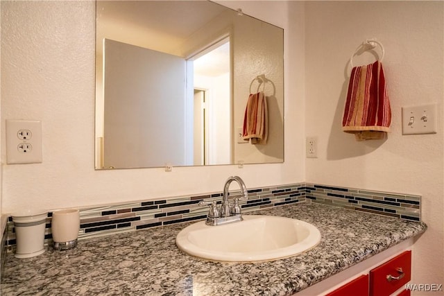 bathroom with tasteful backsplash and vanity