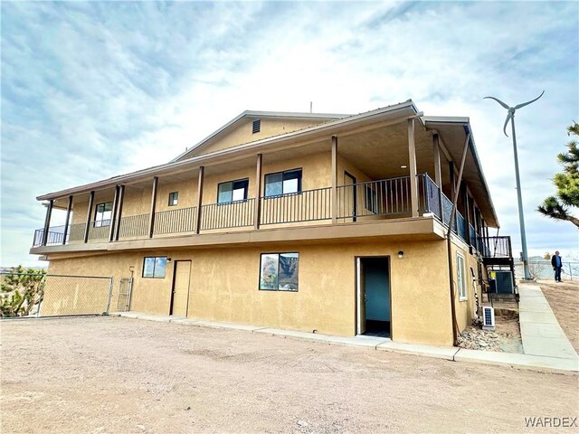 rear view of property featuring a balcony and stucco siding