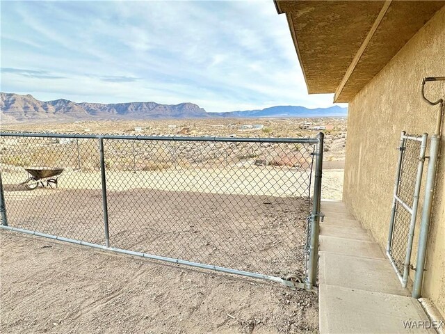 view of gate with fence and a mountain view