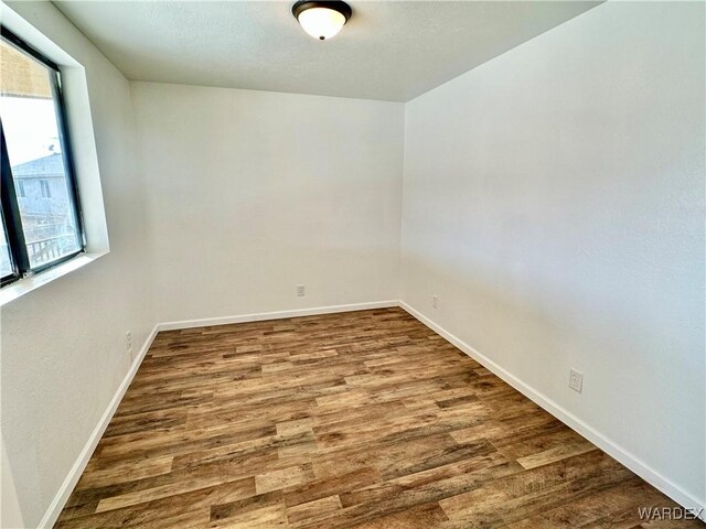 unfurnished room featuring wood finished floors and baseboards