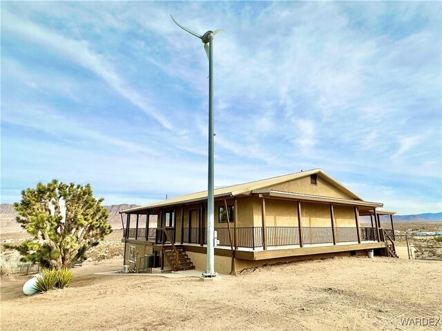 rear view of property featuring a mountain view and stucco siding