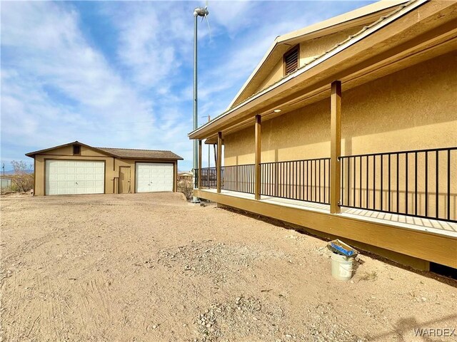 view of property exterior with an outbuilding, a detached garage, and stucco siding