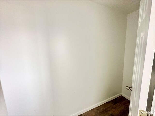 spare room with dark wood finished floors and baseboards