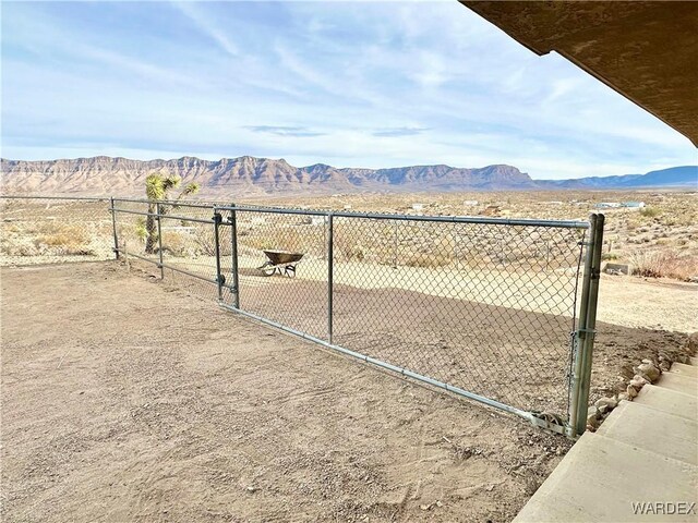 view of yard with a gate, a mountain view, and fence