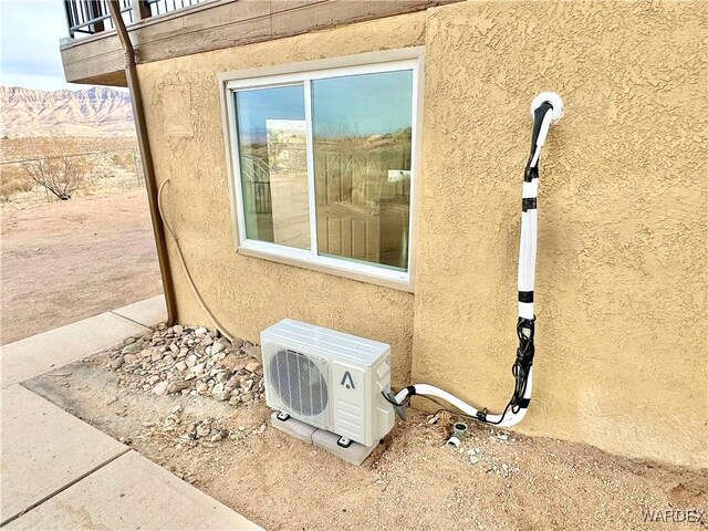 details featuring ac unit and stucco siding