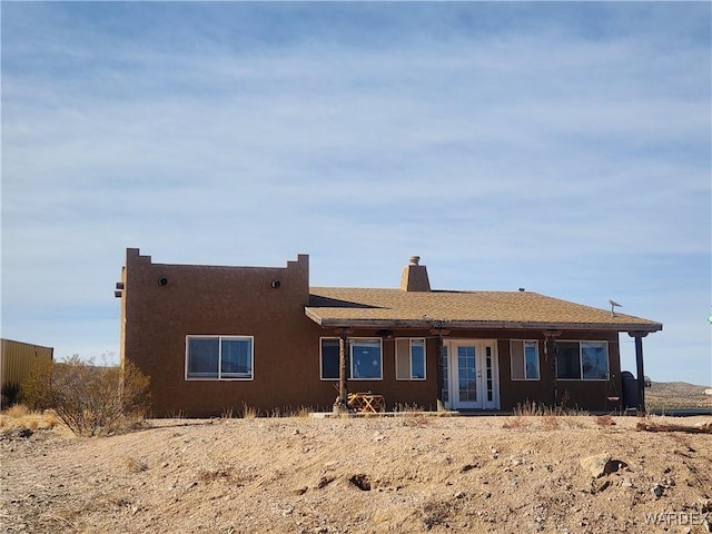 view of front of house with a chimney and stucco siding