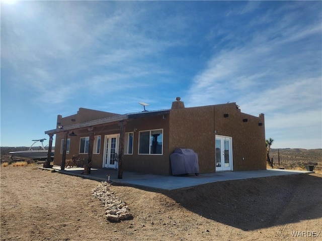 back of house featuring a patio area, stucco siding, and french doors