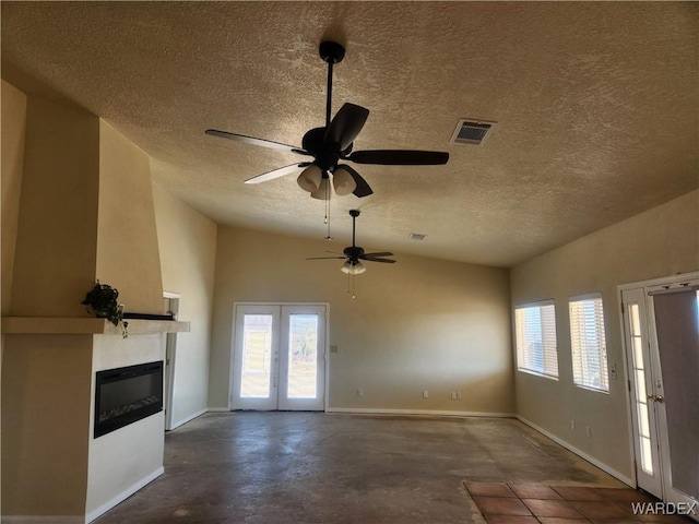 unfurnished living room with a textured ceiling, baseboards, visible vents, a large fireplace, and ceiling fan