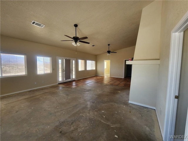 unfurnished living room with unfinished concrete floors, a textured ceiling, ceiling fan, baseboards, and visible vents