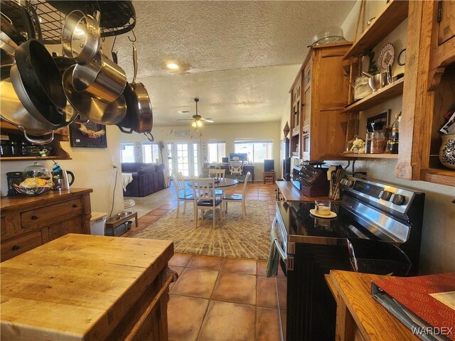 kitchen with light tile patterned floors, open shelves, electric range, wood counters, and a textured ceiling