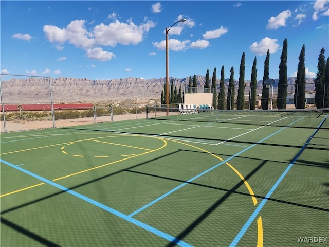 view of basketball court with community basketball court, fence, a tennis court, and a mountain view