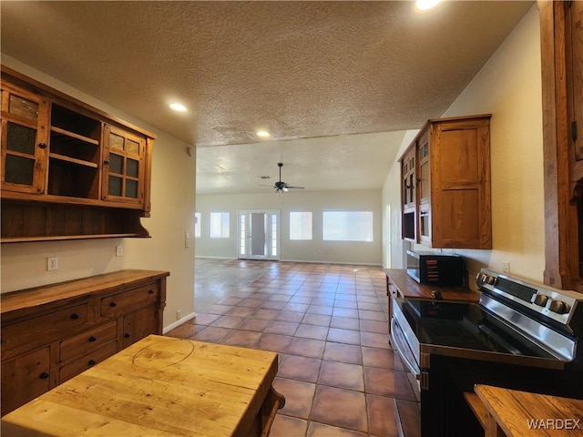 kitchen with brown cabinets, stainless steel range with electric stovetop, wooden counters, and a ceiling fan