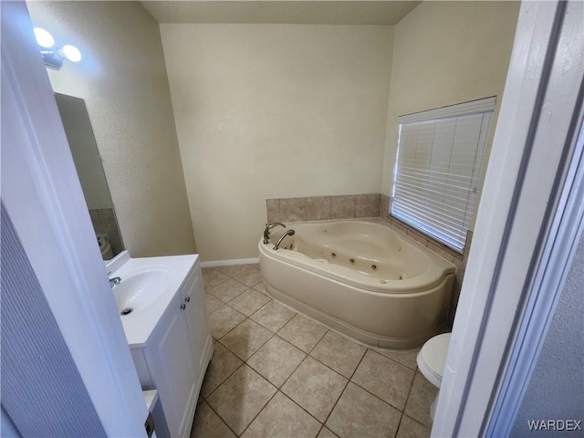 full bath featuring tile patterned floors, toilet, baseboards, a jetted tub, and vanity