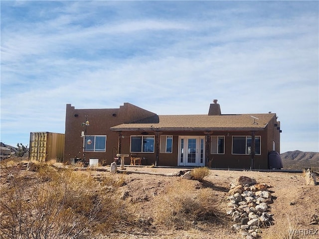 rear view of property with a patio, fence, french doors, stucco siding, and a chimney