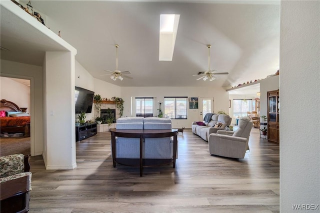 living room with high vaulted ceiling, dark wood finished floors, a fireplace, and ceiling fan