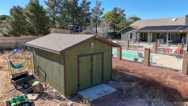 view of shed featuring fence and a fenced in pool