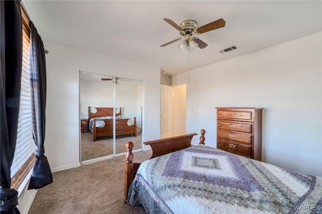 carpeted bedroom featuring ceiling fan, a closet, visible vents, and baseboards