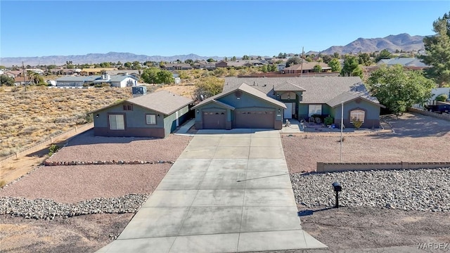 single story home with driveway, a residential view, and a mountain view