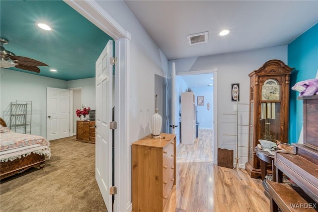 corridor featuring baseboards, light wood-style flooring, visible vents, and recessed lighting