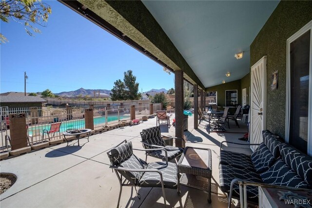 view of patio featuring a fenced backyard, a community pool, and a mountain view