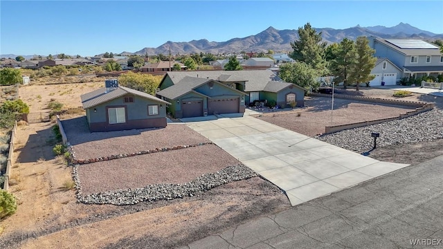 ranch-style house with a garage, a residential view, a mountain view, and driveway