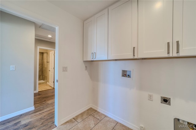 washroom featuring light wood-style flooring, washer hookup, baseboards, cabinet space, and electric dryer hookup